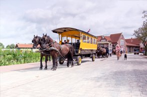 Eine Pferdekutsche steht vor dem Bahnhof in Langeoog.
