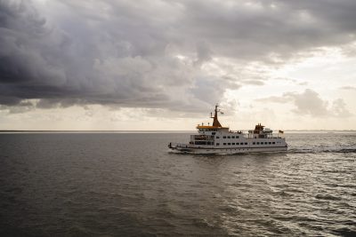 Eine Langeoogfähre auf dem Meer im Sonnenuntergang